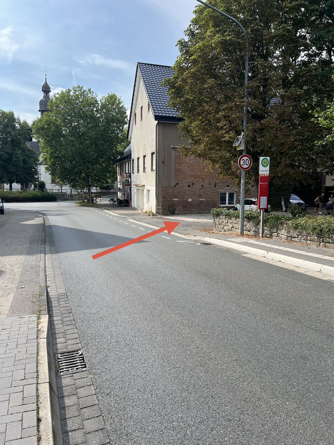 Zufahrt zum Parkplatz an der Blomberger Straße mit rotem Richtungspfeil